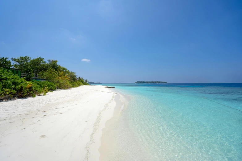 an expanse of water next to a sandy beach