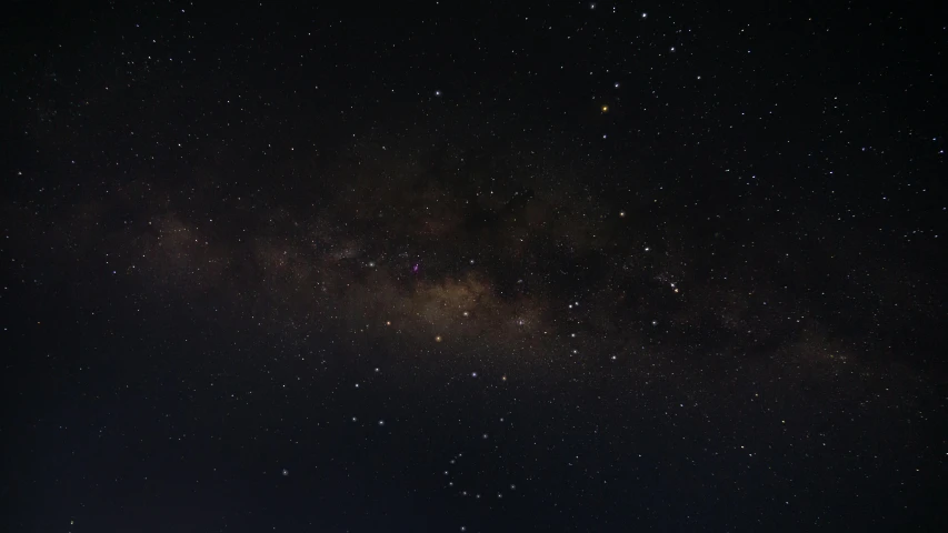 night sky full of stars and clouds, with a few light spots