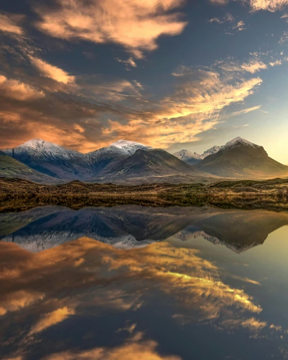 the mountains are reflecting in the still lake