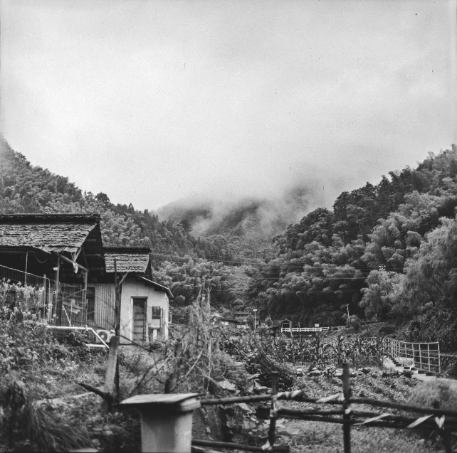 an old black and white po shows a fenced in yard with a shed