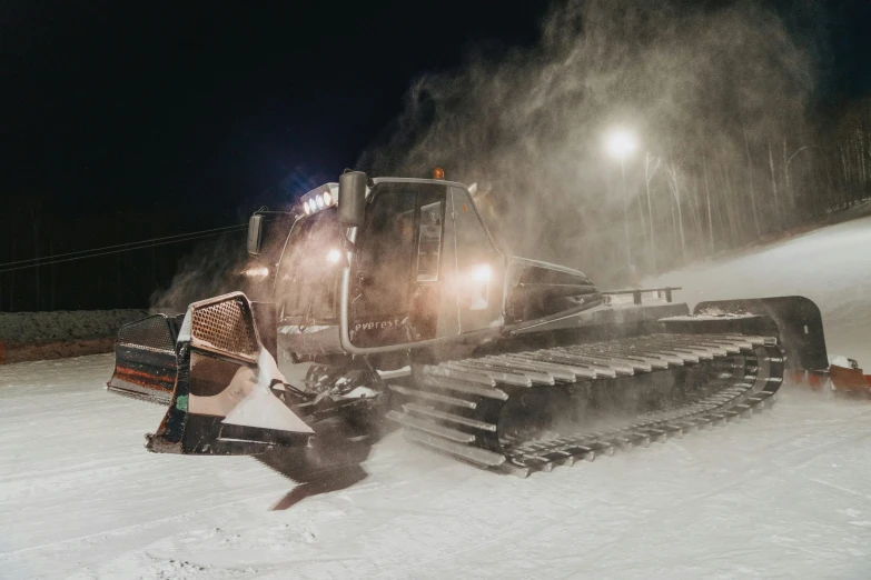 the tractor is in motion driving through the snow