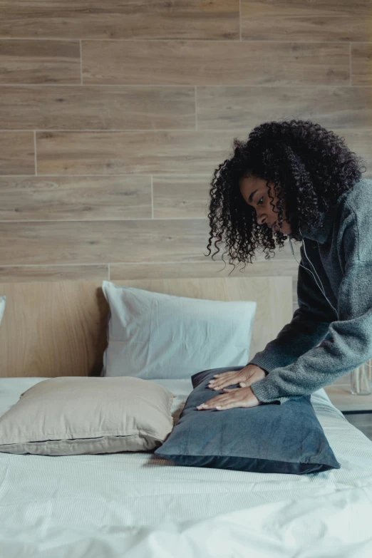 a woman kneeling over a pillow on top of a bed