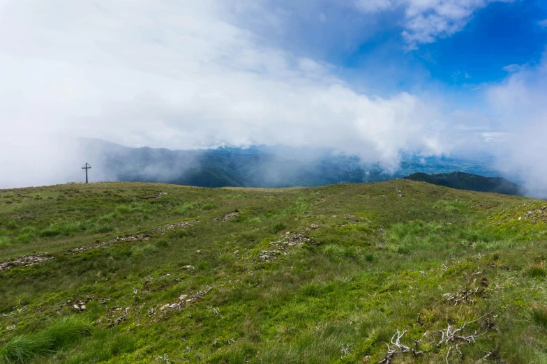 a field with a small bench and mountains in the background