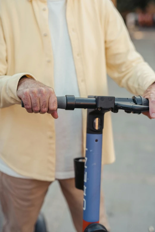 the man is riding the scooter with one hand