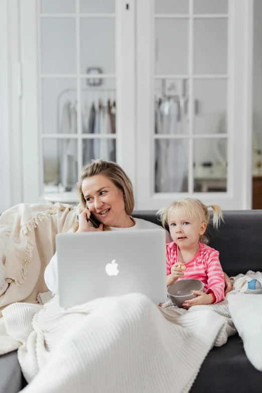 a woman is talking on her cell phone while her toddler watches