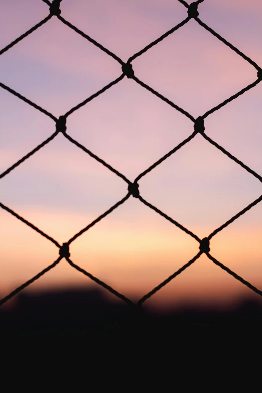 the view through a chain link fence at the dusk