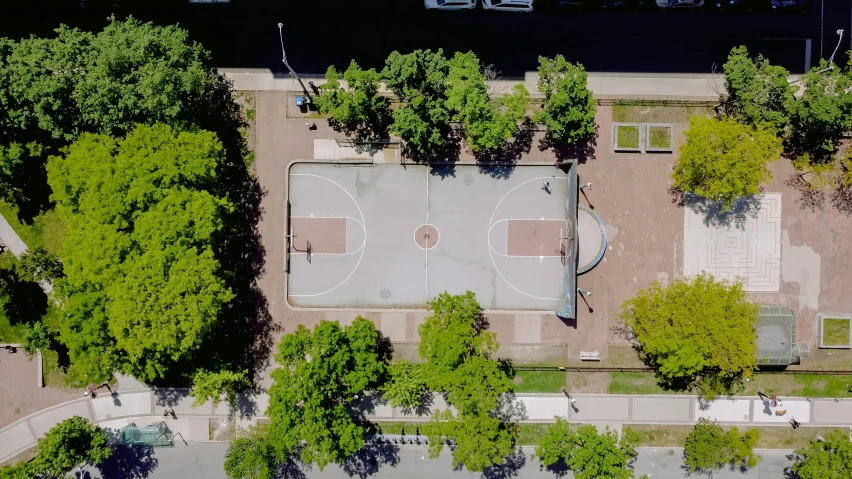 an aerial view of a small park with trees in the background