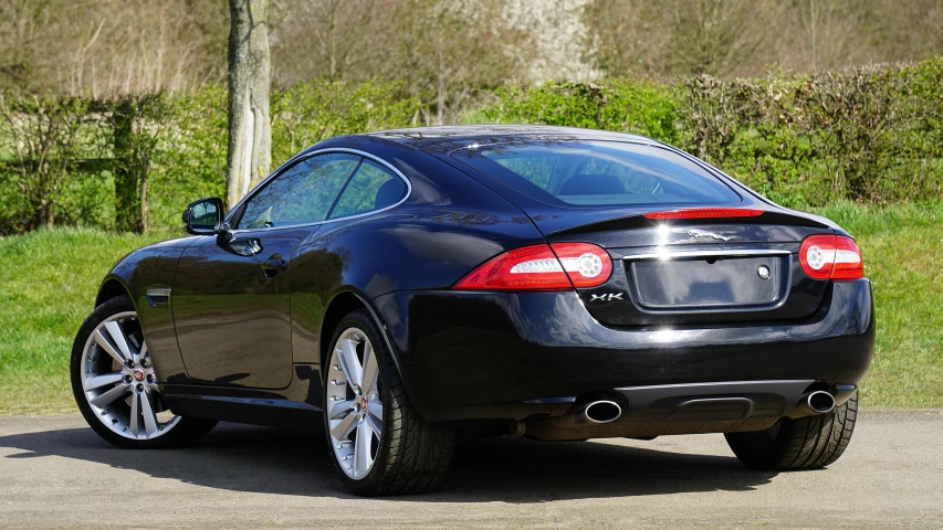 the back end of a black maserato parked in a lot