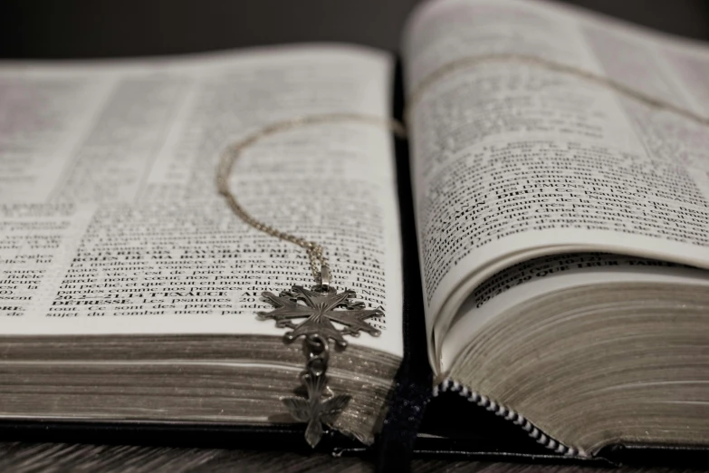 the cross necklace is placed on an open book