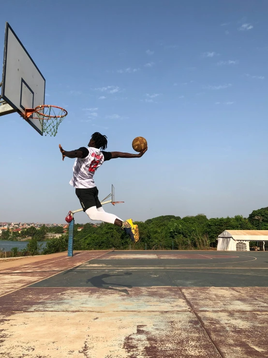 a man holding a basketball jumps up to grab it