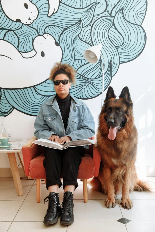 a person sitting on a red chair next to a dog