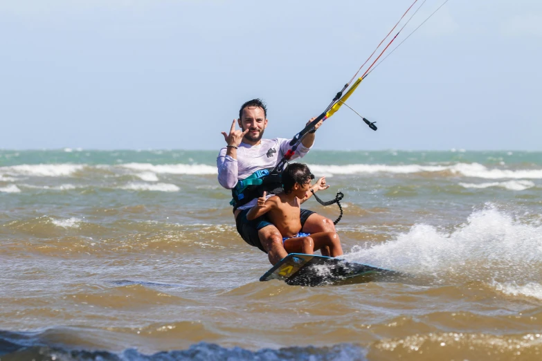 a man and two s riding a surfboard