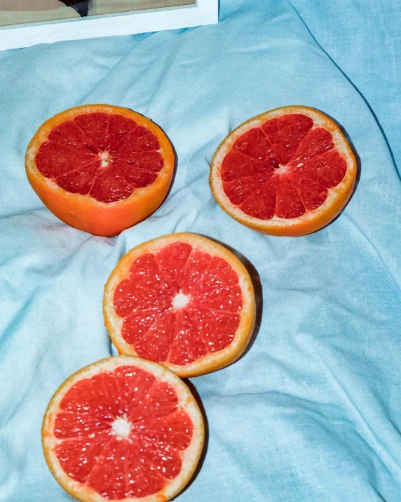 there is one gfruit sliced in half and the other whole is