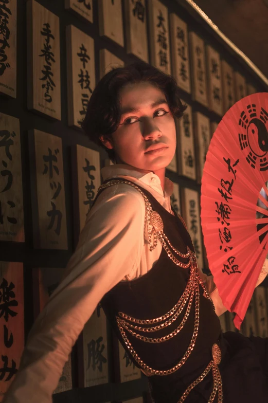 the oriental dancer is posing with his red fan