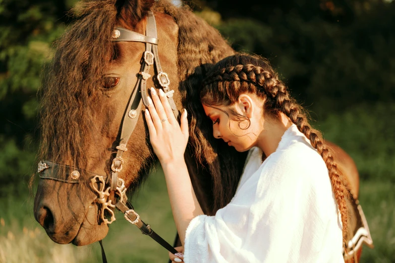 a woman wearing a id is petting the head of a horse