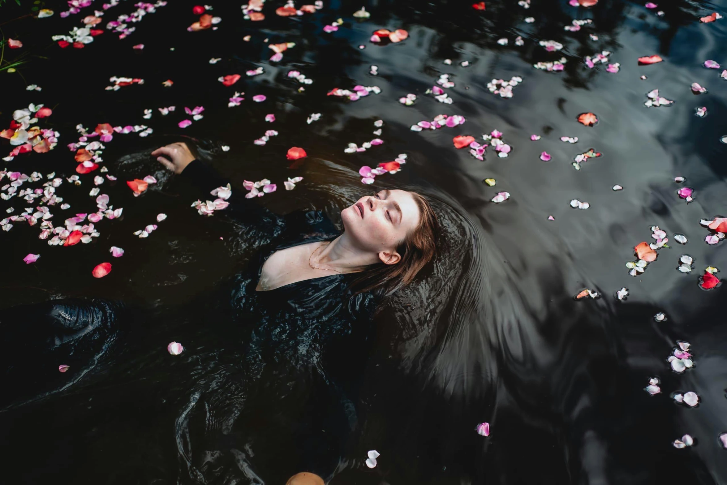 a woman floats in the water and looks up from the bottom