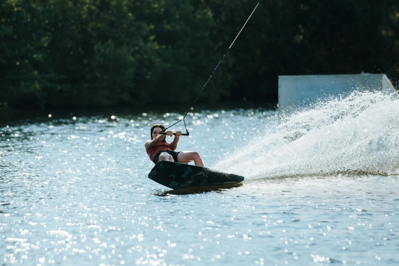 a person riding a wake board while holding onto some wire