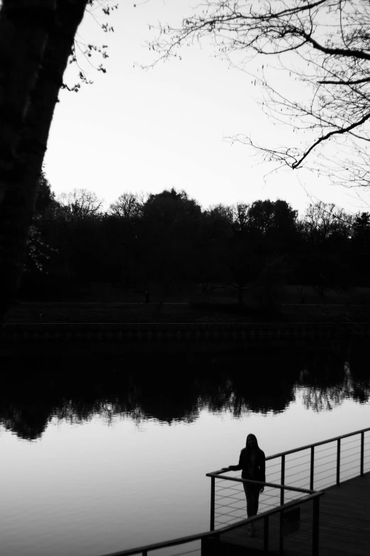 a person standing by a lake looking at the water