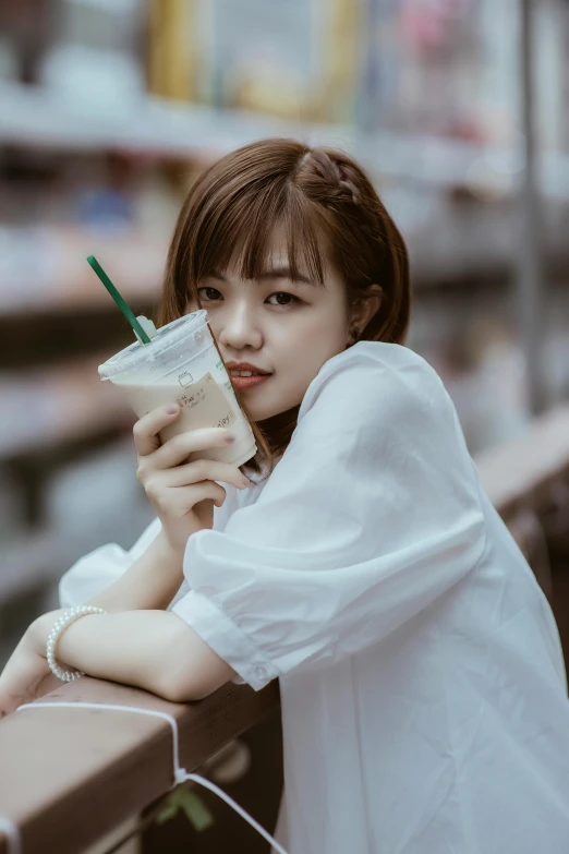 an asian girl leaning on a shopping cart and looking at her phone