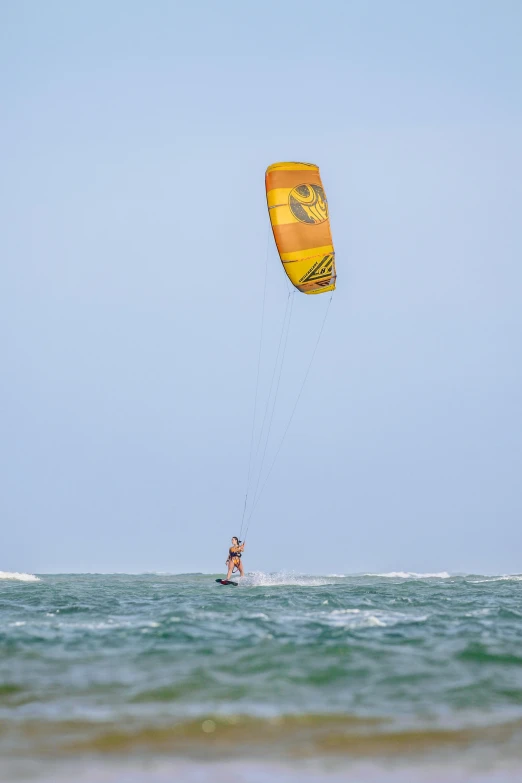 person kiteboarding over the ocean with the wind being blown