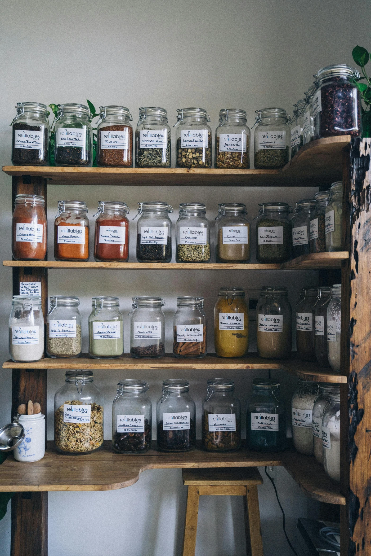 jars with labels are arranged on shelves in a room