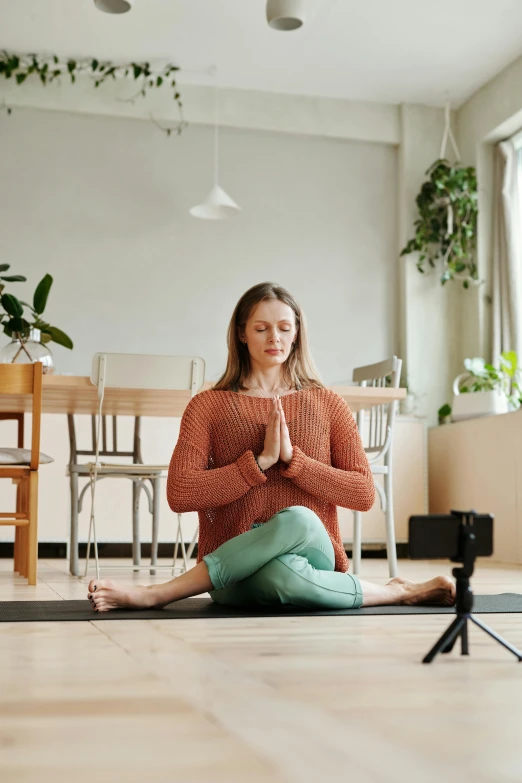 a woman sitting in a yoga position on the floor