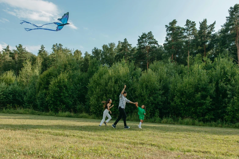 two people and a little boy fly a kite