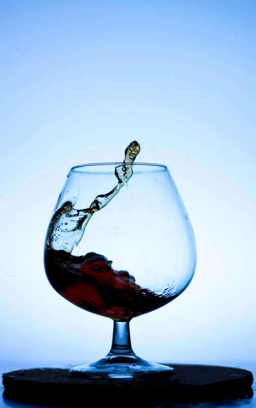 an upside down glass containing liquid with the shape of a person's hand