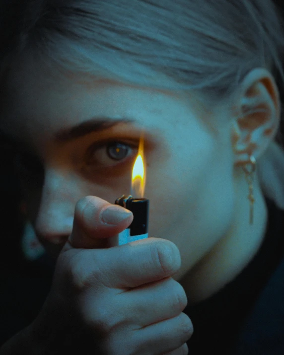 a woman holding up a lit lighter as she holds it in her right hand