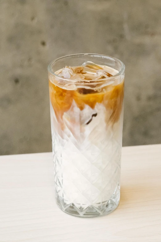 an iced drink with cream and coffee inside of a glass