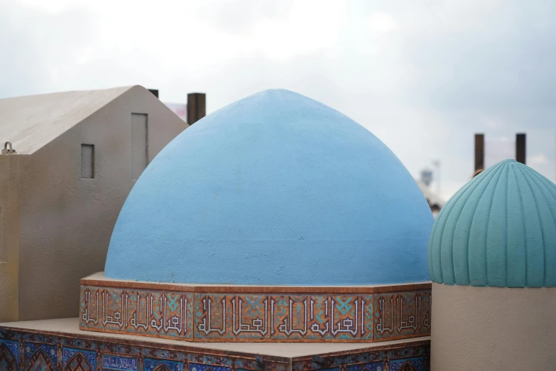 a blue dome near two tan buildings