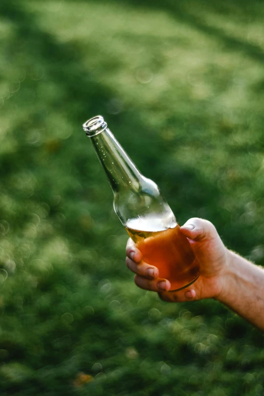 a person holding up a bottle and beer