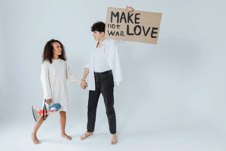young couple holding up a sign reading make wild love