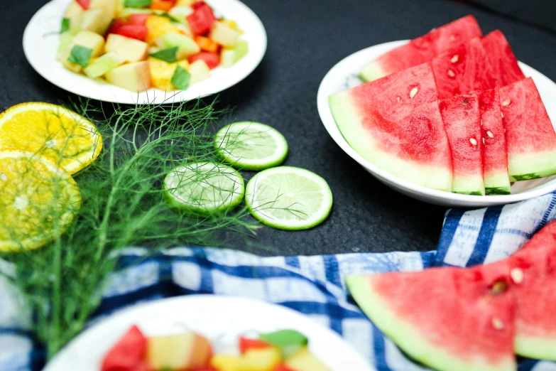 a bunch of plates with sliced fruits on them