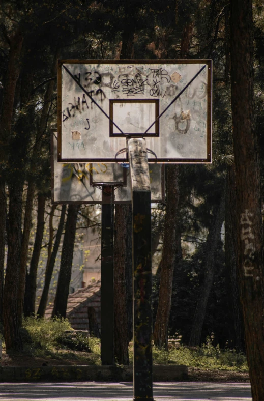 there is graffiti writing on the backboard of a basketball hoop