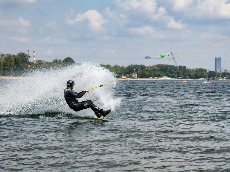 a man in black water skiing while holding onto his board