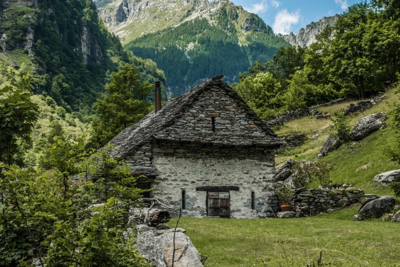 a small house in the mountains near some trees