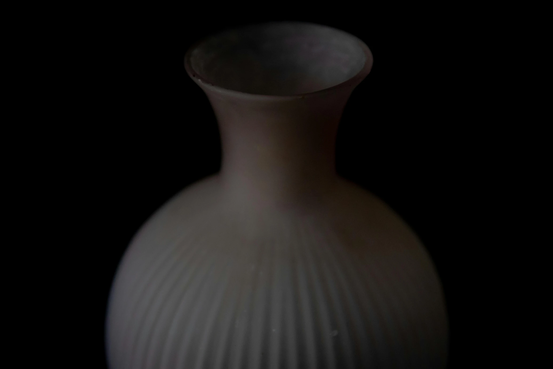 a vase with wavy lines of white on a black background