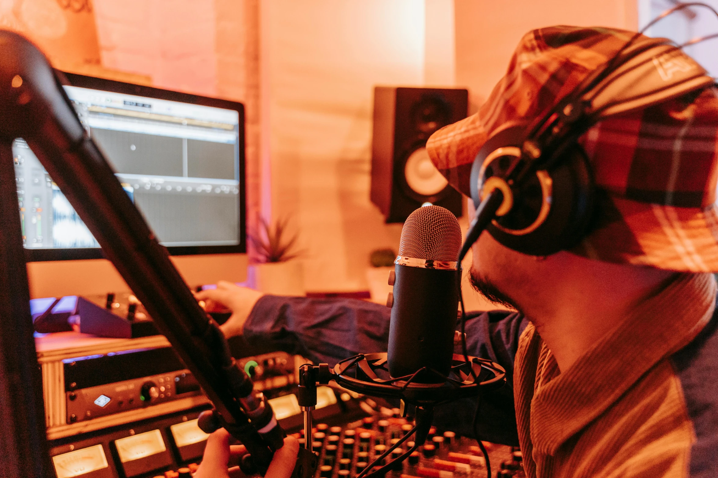 man with headphones on holding microphone up to screen