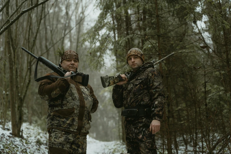 two hunters posing for the camera with their guns