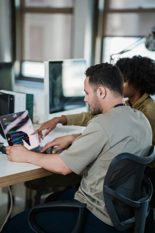 a man is typing on his laptop at his desk