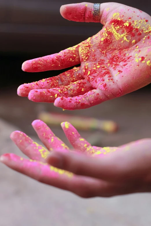 a person's hand holding yellow paint over it