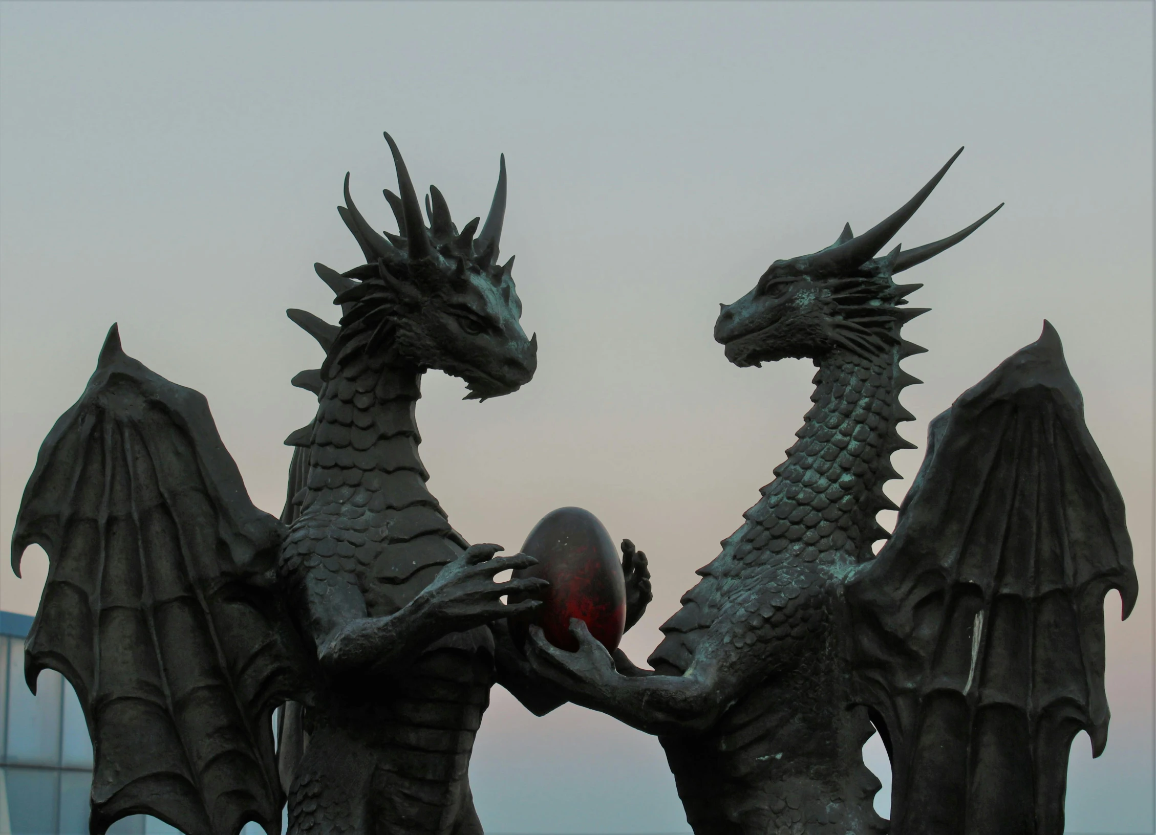 a pair of large statues in front of the ocean