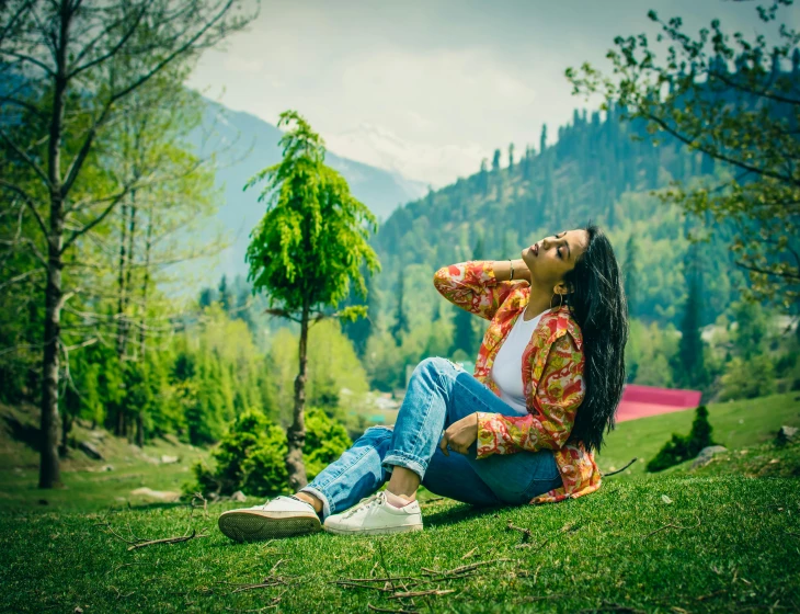 a person sitting on the ground in front of trees