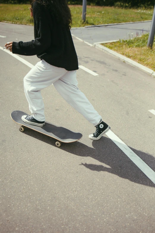 there is a woman riding a skateboard down the road