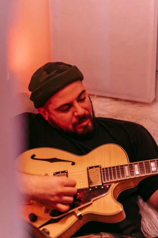 a man with a beard playing a guitar