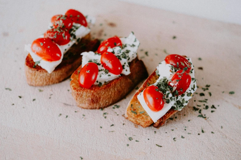 small pastries with tomatoes and sour cream on them