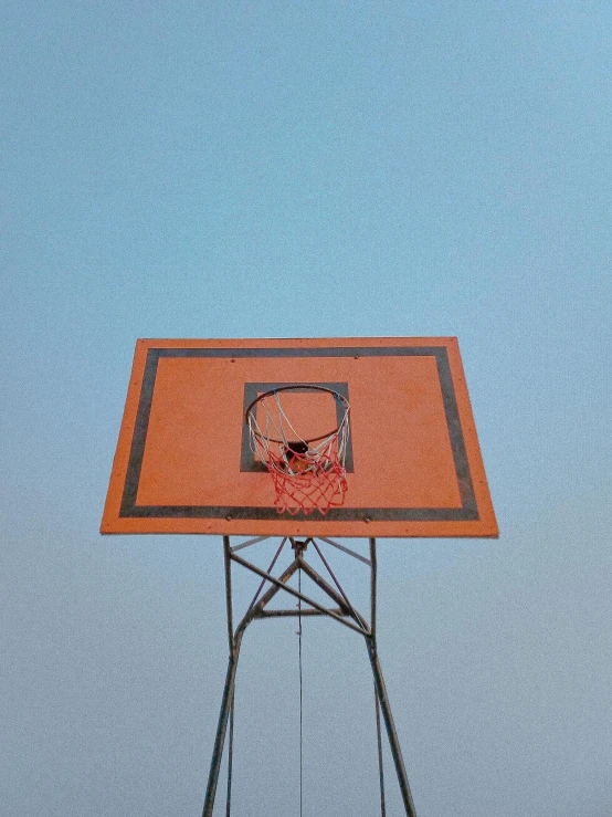 an empty basket ball hoop with a blue sky in the background