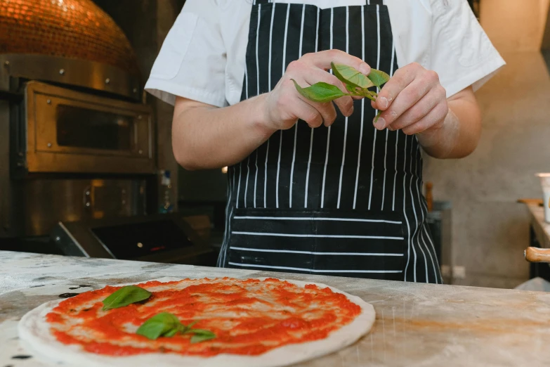 a pizza chef preparing a personal size pizza