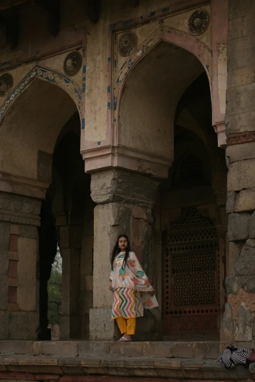 a woman with a colorful dress standing in an open archway